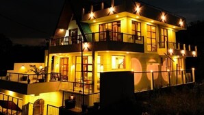 A multi-story building with balconies and a lit exterior at night. - Affinity Villa Dikoya (Dick oya)