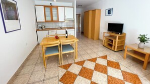 A compact living space with a kitchen, dining area, and a TV stand. - Apartman Villa Ljiljana 2 (Jadranovo)