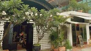 A building with a blue facade, a sign reading "CAT MULLA," and a covered outdoor seating area with potted plants. - Bat Chum Villa (Phnom Penh)