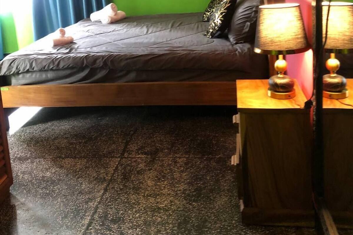 A room with a bed, a lamp, and a mirror.