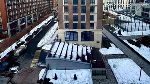 Un bâtiment moderne doté d’un atrium central, entouré d’un parking et d’un terrain enneigé.