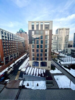 A modern building with a central atrium, surrounded by parking and snow-covered ground.