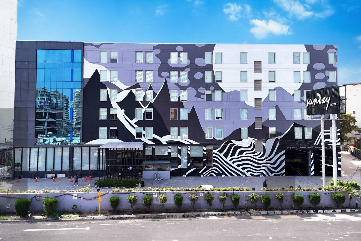 Een modern hotel met een opvallende gevel, gekenmerkt door geometrische patronen en grote ramen.