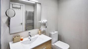 Een haardroger, handdoeken, zeep, toiletpapier