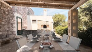 An outdoor dining area with a stone wall, a built-in oven, and a pergola. - Villa Vittoria in Ostuni (Ostuni)