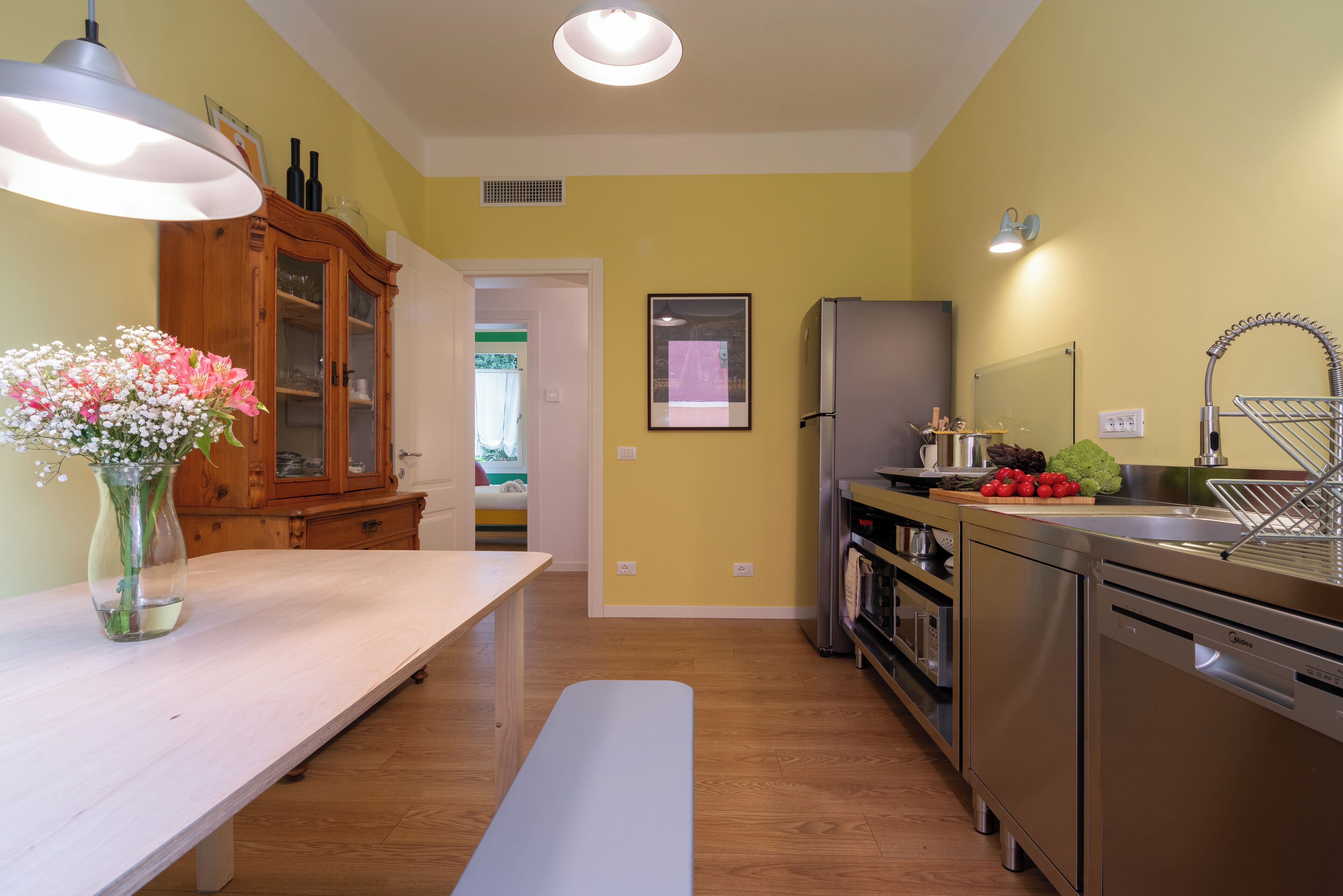 Una cocina moderna con una mesa de madera, un banco y un florero.