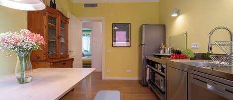 Una cocina moderna con una mesa de madera, un banco y un florero.