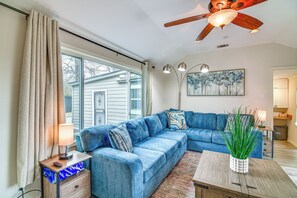 A living room with a blue sectional sofa, a wooden coffee table, a lamp, and a ceiling fan. - Spacious Memphis Retreat: 5 Mi to Downtown Beats! (Memphis)