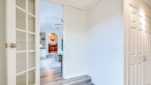 A hallway with a wooden floor, white walls, and a door with a glass panel. - Spacious Memphis Retreat: 5 Mi to Downtown Beats! (Memphis)