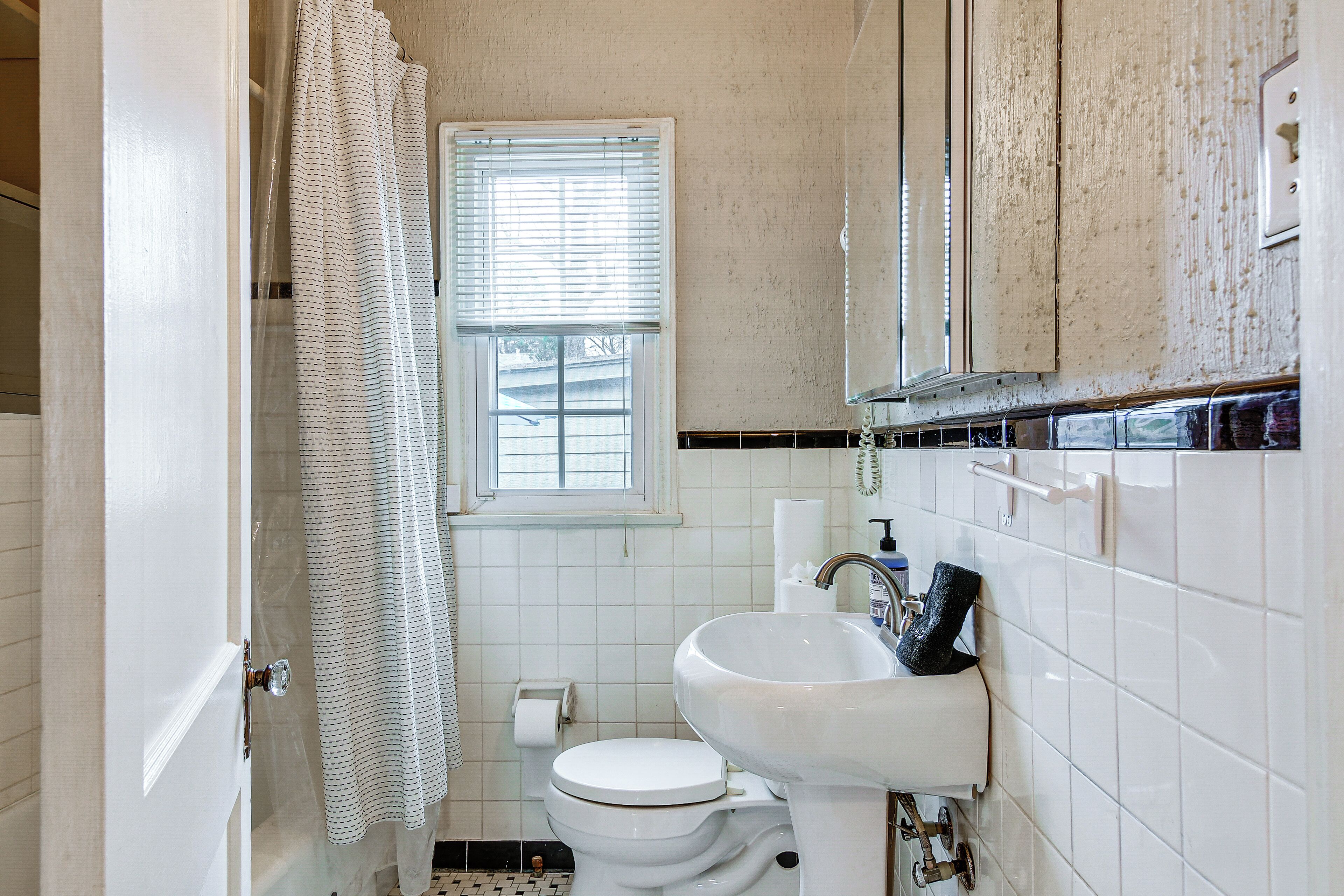 Un baño con inodoro, lavabo y ventana.