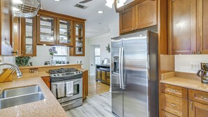 A kitchen with wooden cabinets, stainless steel appliances, and a granite countertop. - Spacious Memphis Retreat: 5 Mi to Downtown Beats! (Memphis)