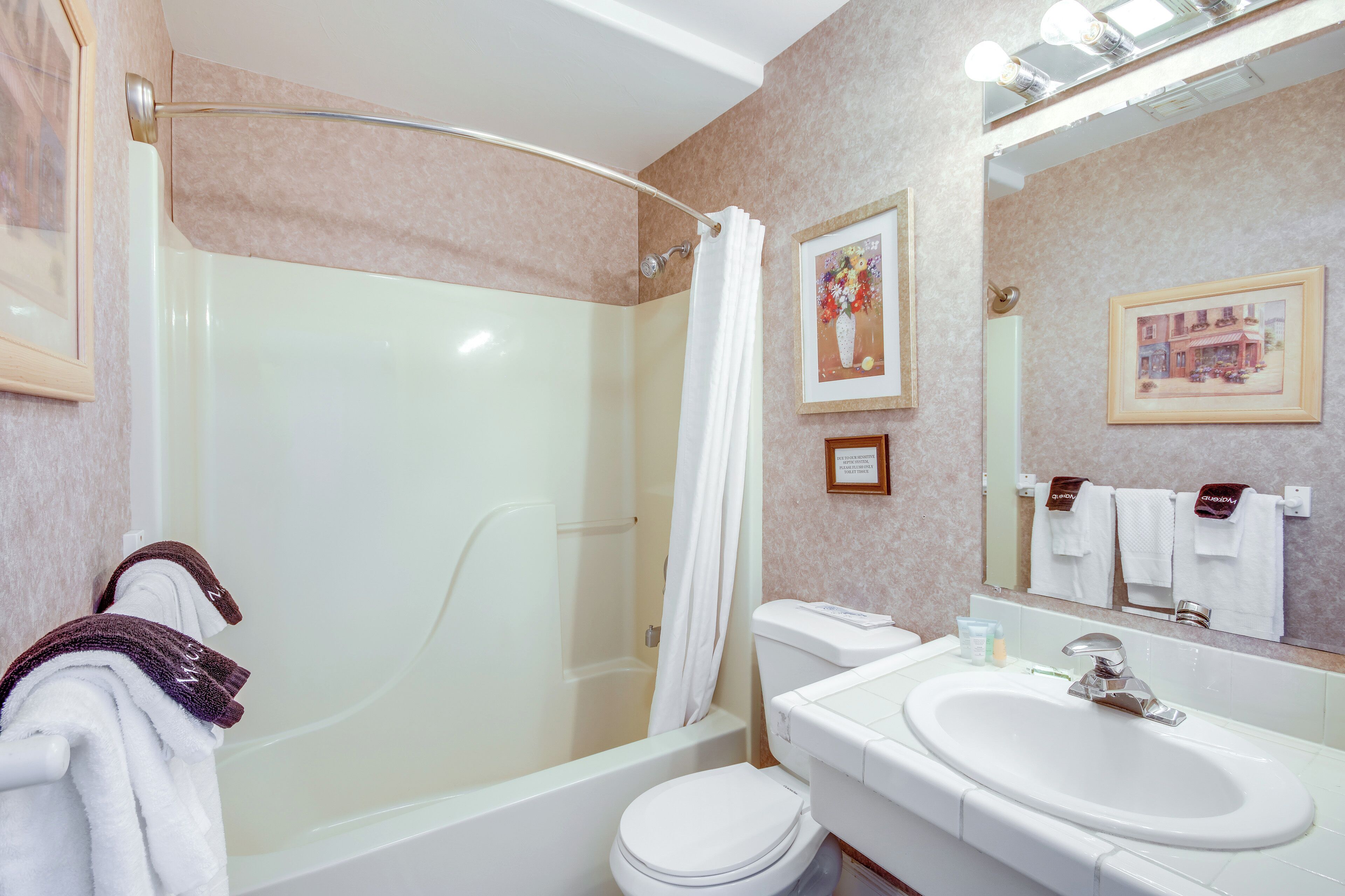 A bathroom with a bathtub, toilet, and sink.