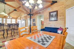 A wooden interior with a dining table, chairs, and a blue sofa.