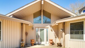 A house with a gabled roof, a front door with a glass panel, and two large planters on either side of the entrance. - Fire Pit, Views: Lakefront Toledo Bend Retreat! (Many)