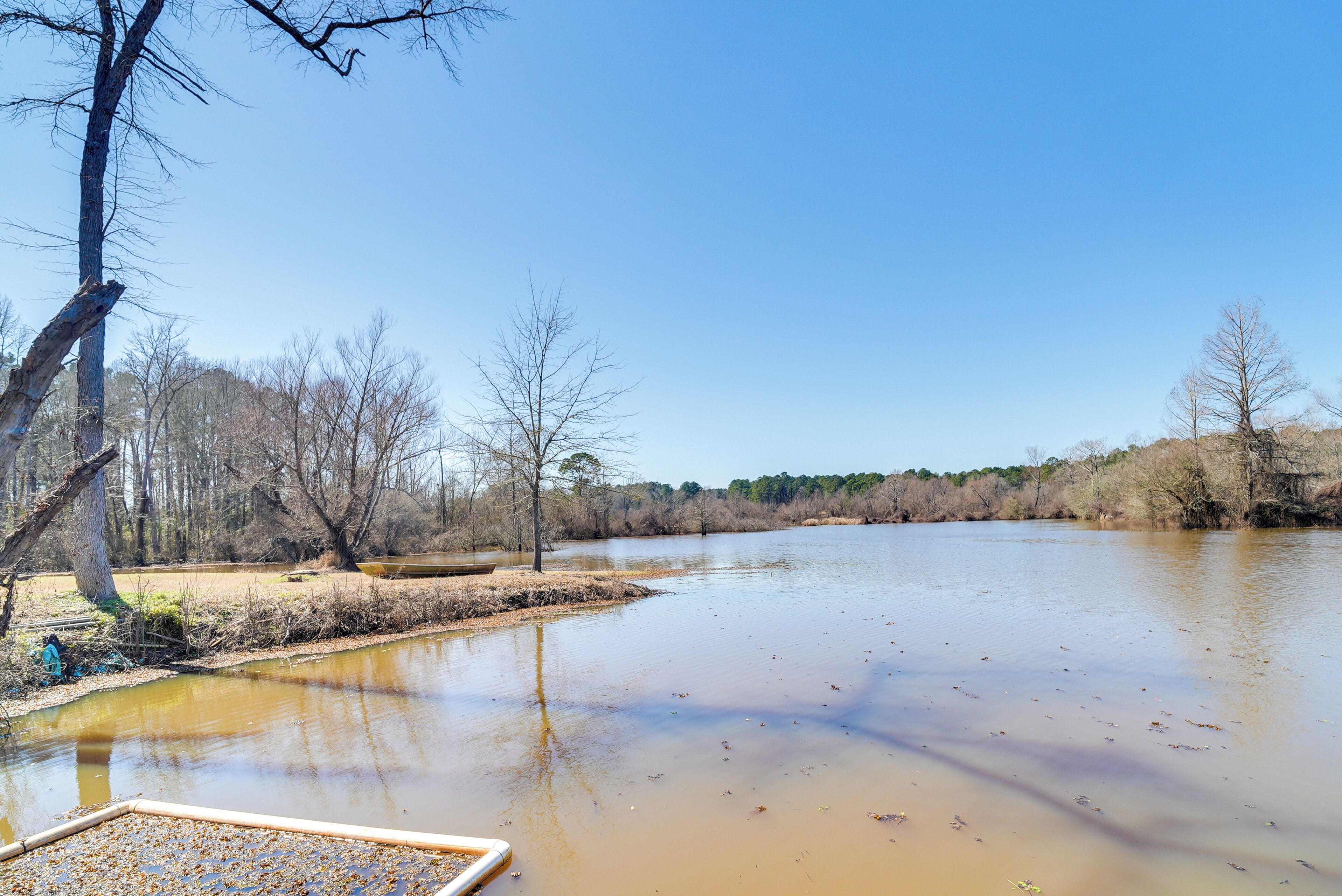 Une rivière avec un quai en bois et un banc.