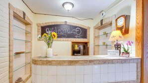 A reception desk with a chalkboard sign, a clock, and a lamp. - Spacious Yellowstone River Retreat w/ Trails! (Emigrant)