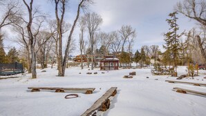 A snowy outdoor area with wooden benches and a gazebo. - Spacious Yellowstone River Retreat w/ Trails! (Emigrant)