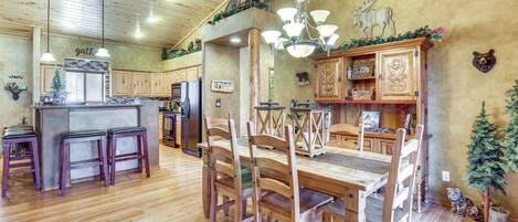 A spacious kitchen with wooden cabinets, a central island, and pendant lighting.