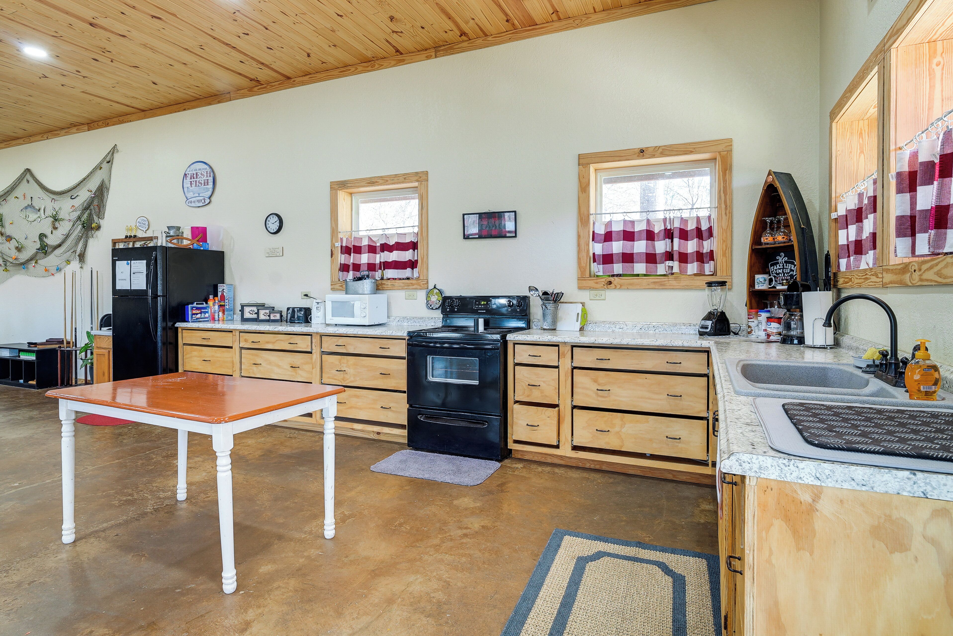 A kitchen with wooden cabinets, a stove, a refrigerator, and a dining table.