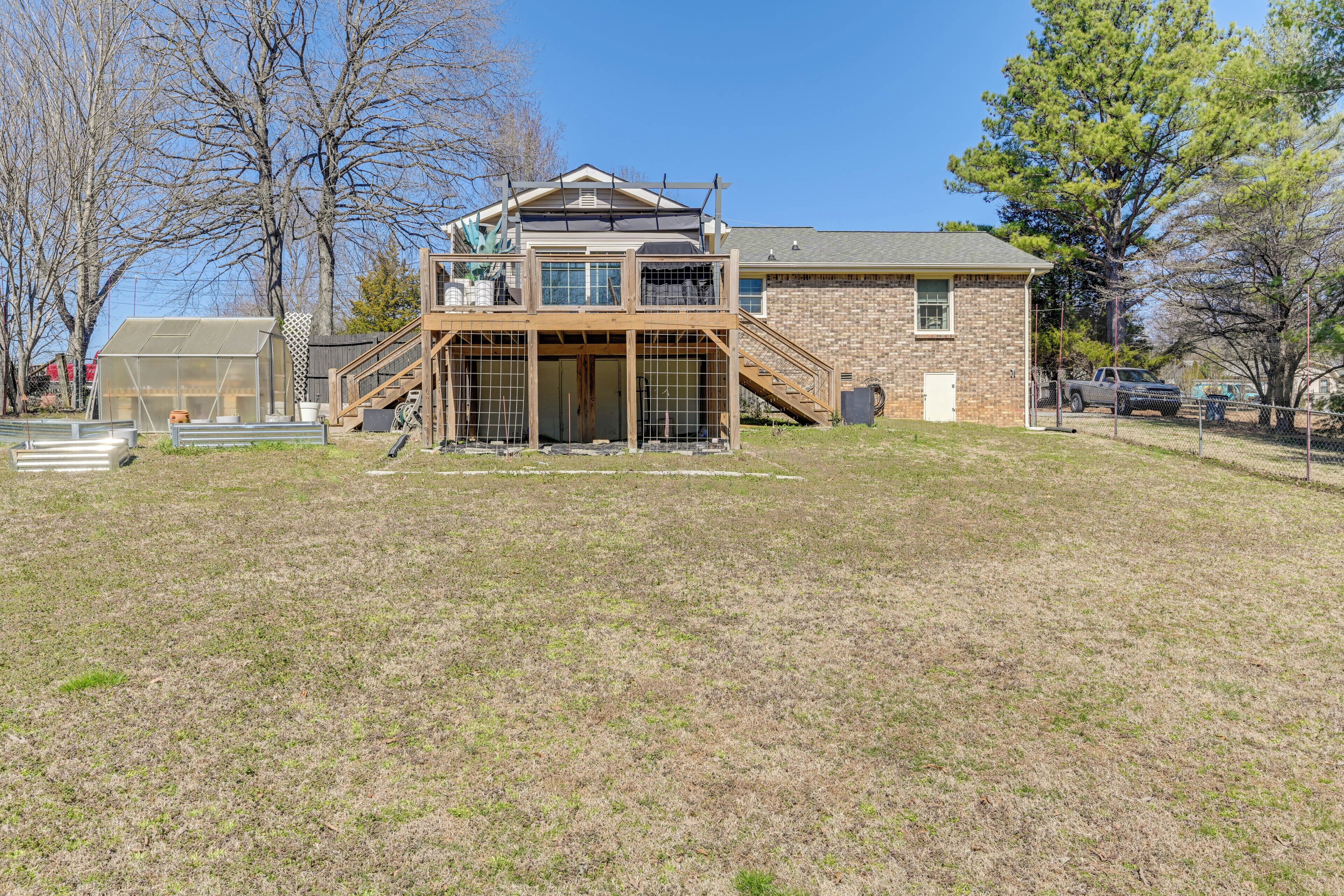 A two-story building with a wooden deck and a fenced area.