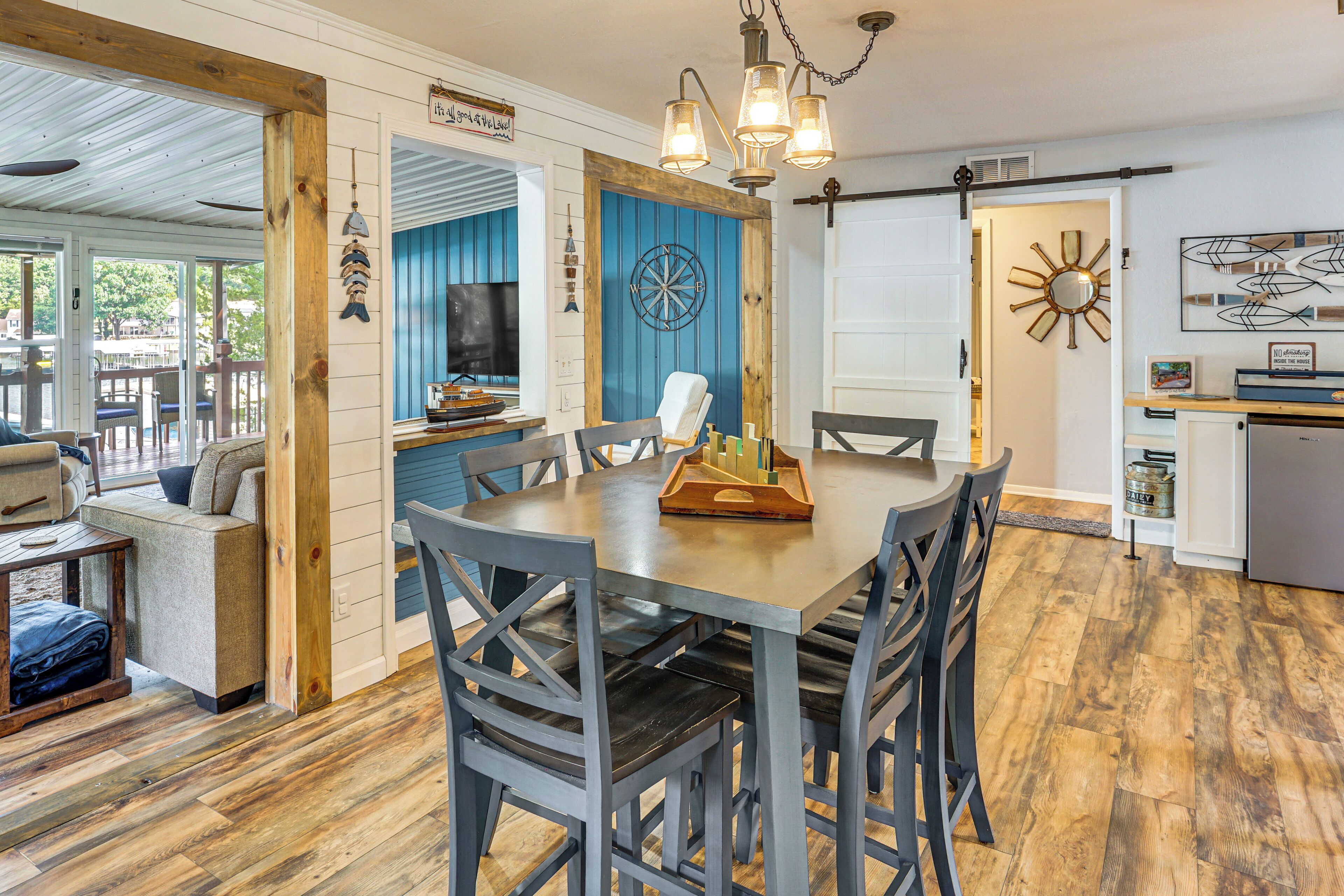 A dining area with a wooden table, grey chairs, and a dartboard.