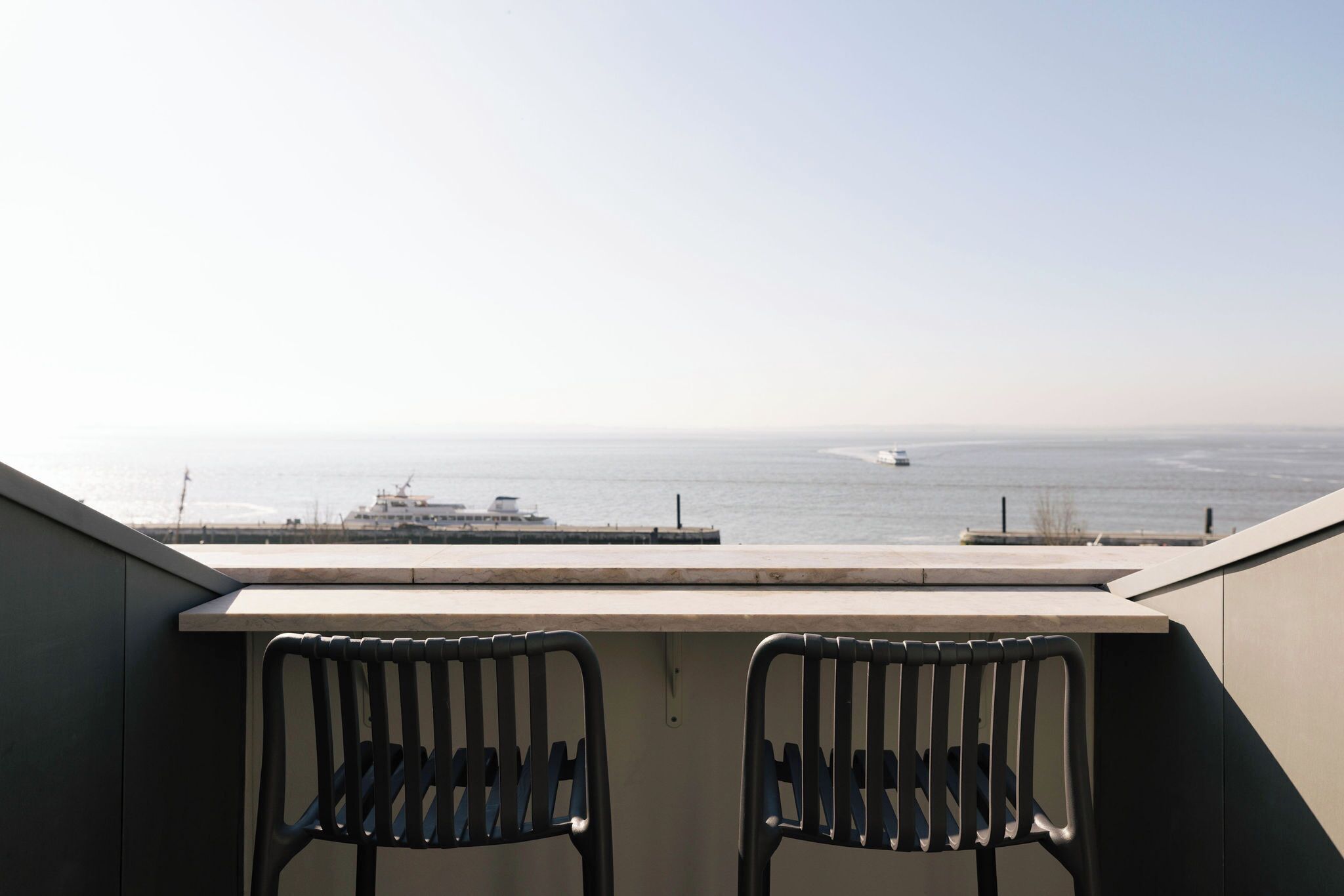 Un balcone con due sedie e vista sul mare.
