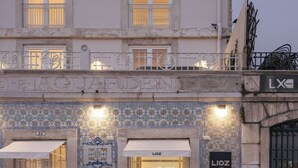A hotel entrance with a tiled facade, outdoor seating, and a visible entrance to the interior. - LIOZ Lisboa (Lisbon)