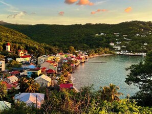 A coastal town with colorful buildings, a dock, and a clear view of the sea.