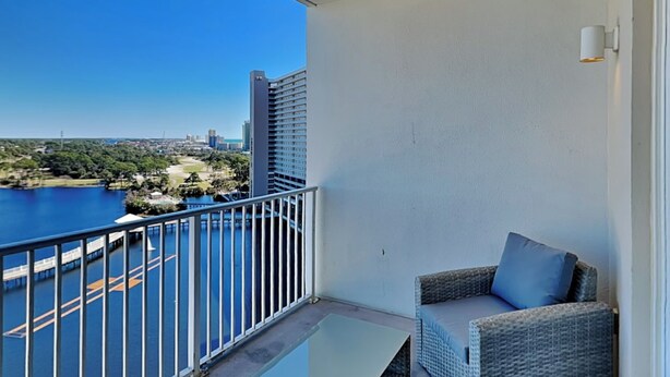 A balcony with a view of a body of water and a cityscape.