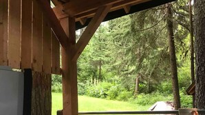 A hot tub with a wooden structure and a view of a forested area.