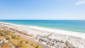 A beach with a road, parking area, and palm trees. - P5-1509 2B Gulf Front Summer Savings! (Pensacola Beach)