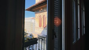 A view from a balcony with a railing, overlooking a street with buildings and a parked car. - Domus Gracchi (Rome)