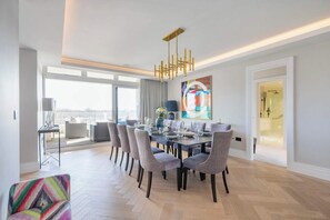 A modern dining area with a large table set for six, surrounded by six chairs.