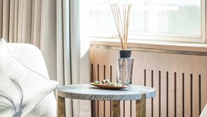 Un saló modern amb una taula rodona, un sofà i una finestra amb cortines.