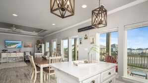 Cozinha espaçosa com uma ilha grande, área de refeições e vista para o bairro.