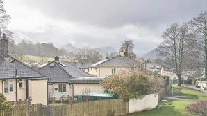 Un barrio residencial con casas, una valla de madera y un patio cubierto de césped.