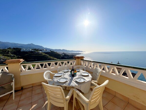 A terrace with a table set for four, overlooking a coastal landscape with mountains and a clear sky. - New Property - Big Terrace with Great Sea Views and Mountain Views - Alcazaba 33 in Nerja (Torrox)