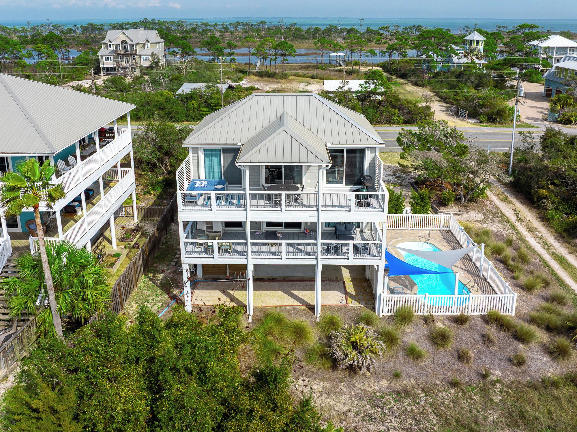 A multi-story house with a balcony and a swimming pool.