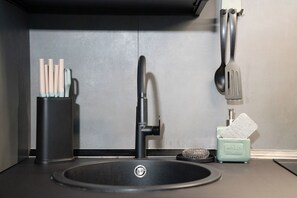 A modern kitchen sink with a faucet, a dish soap dispenser, and a utensil holder. - Oktò apartments Milazzo: Studio Standard (Milazzo)