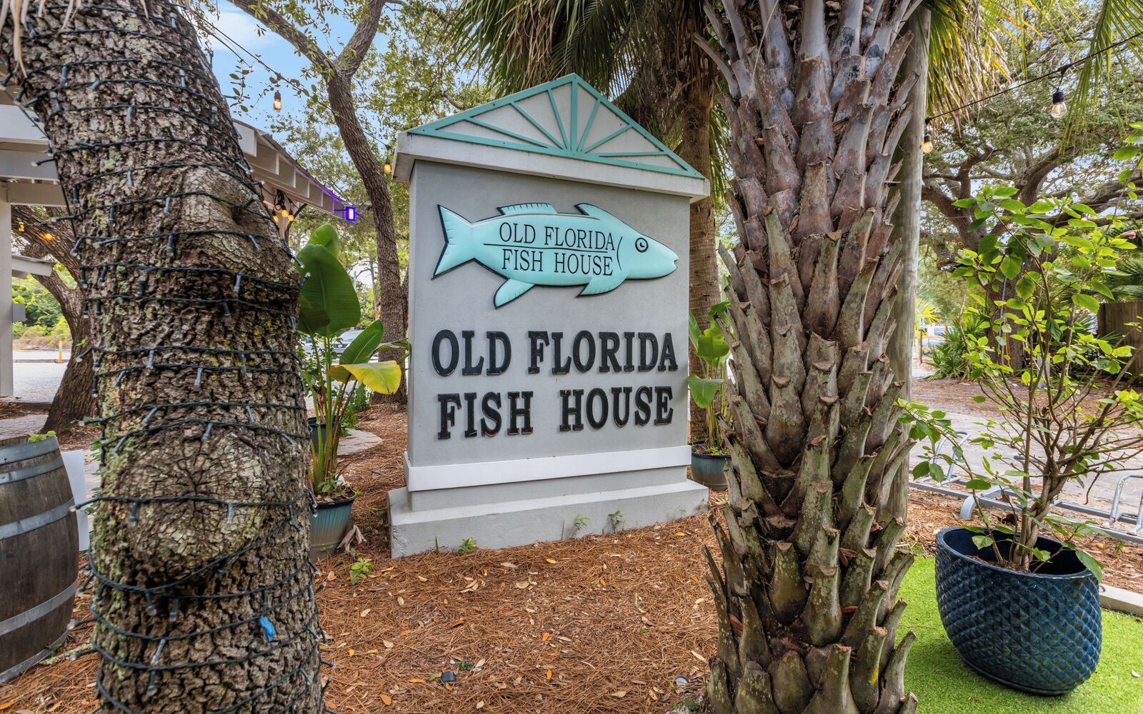 A sign for Old Florida Fish House with a fish-shaped top.