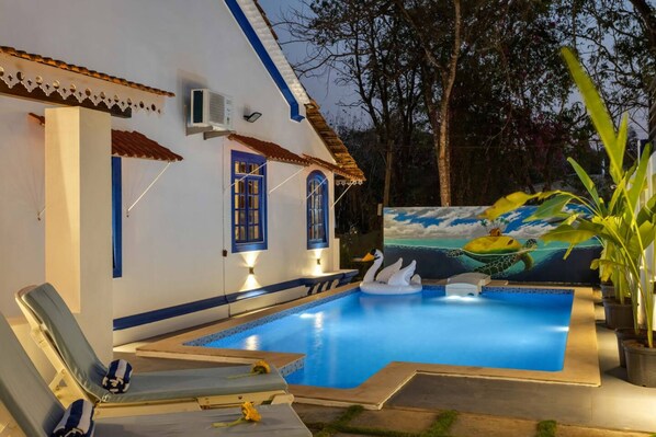 A swimming pool with lounge chairs, a mural of sea creatures, and a building with blue accents. - 3bhk Portuguese-style Villa w Pool Casa Aloma (Assagao)