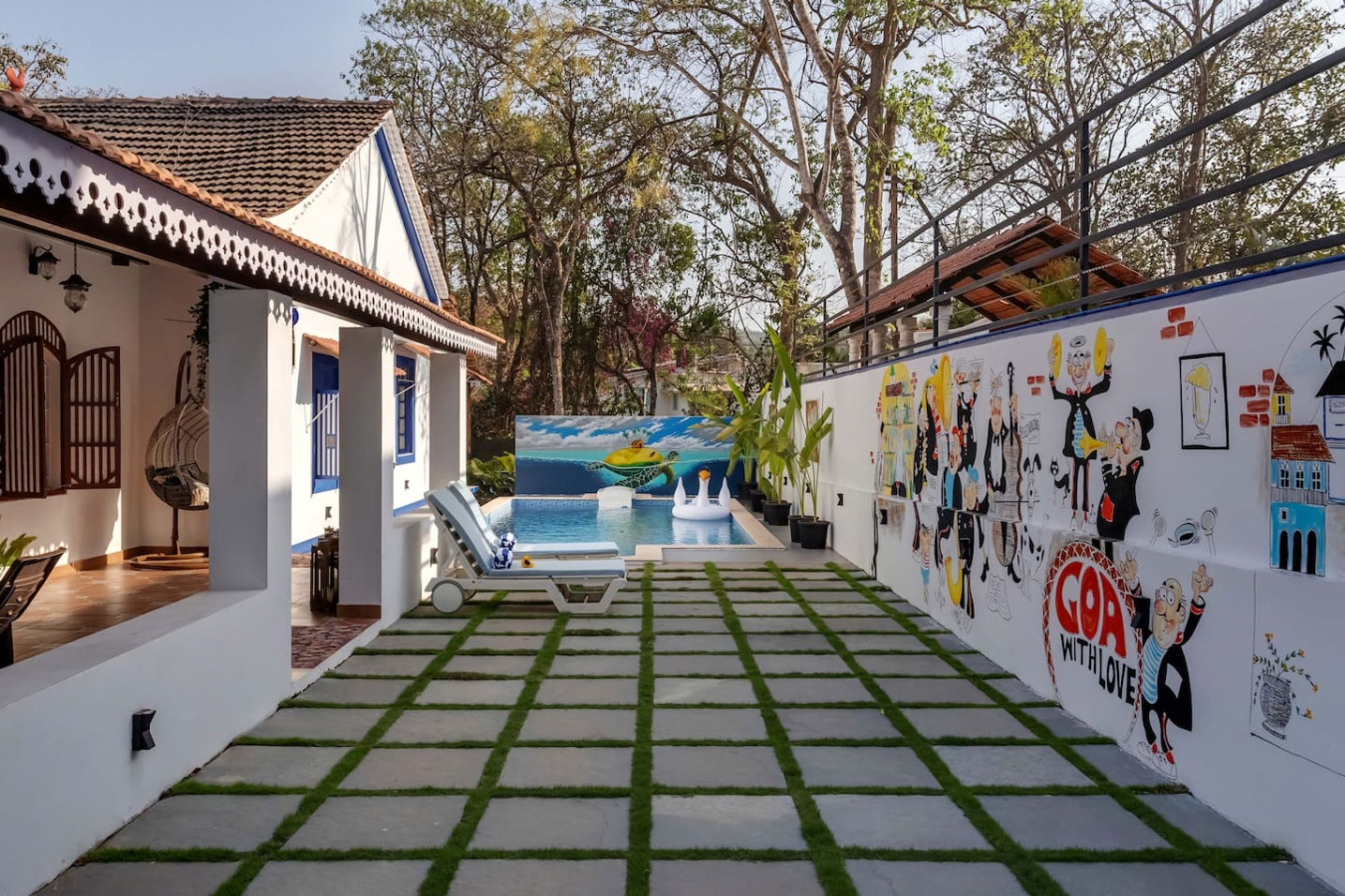 A courtyard with a swimming pool, a mural, and a wall decorated with cartoon characters.