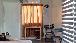 A room with a bed, a desk, and a window with blinds. - Asuneus Farm (Carmen)