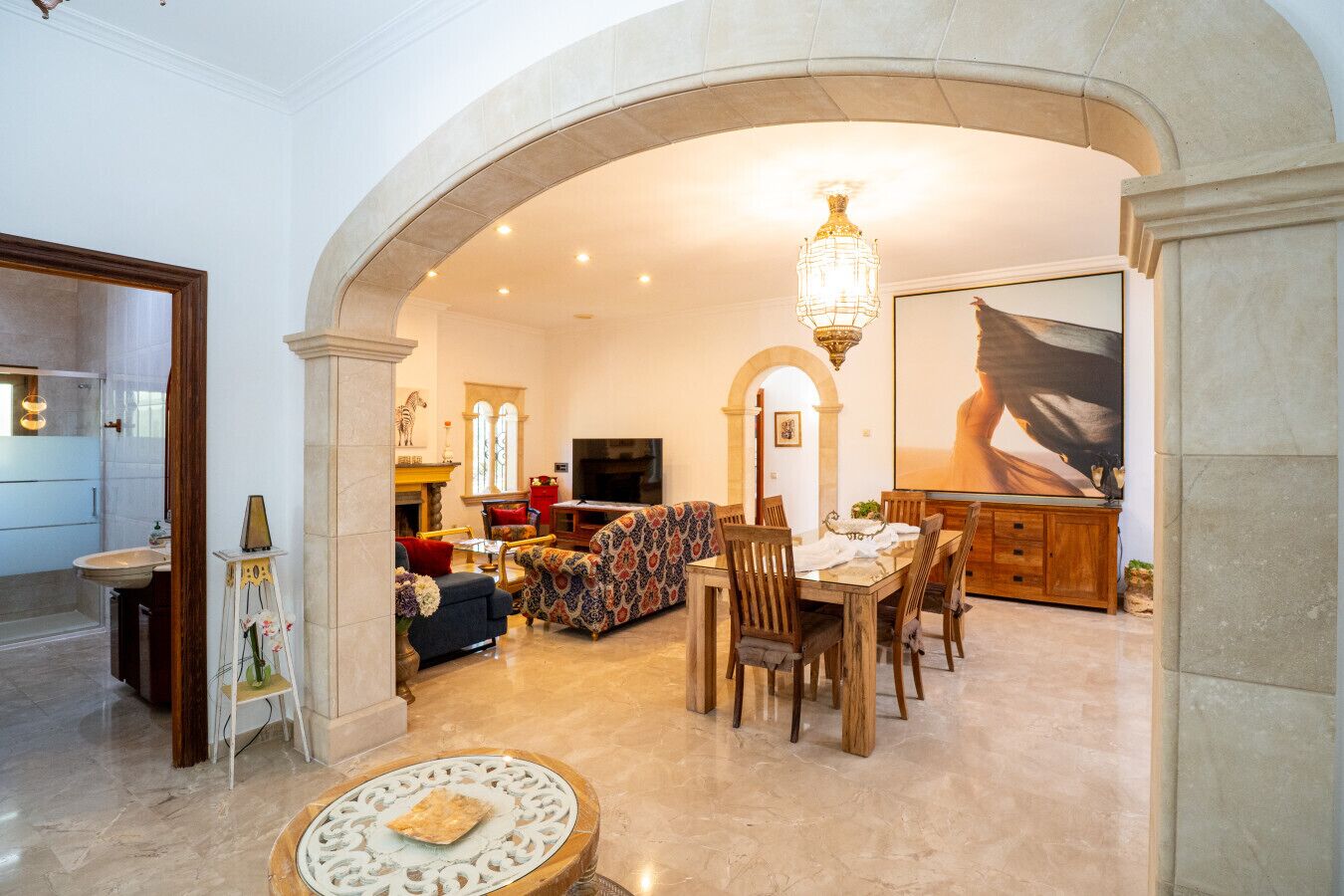 A spacious living area with a dining table, sofas, and a fireplace.