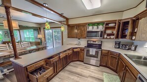 A modern kitchen with wooden cabinets, a large island, and built-in appliances.