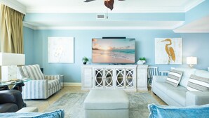 A living room with a television, two sofas, a coffee table, and a cabinet with decorative items.