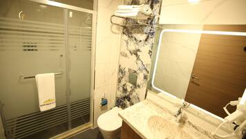 Een aparte badkuip en douche, een bubbelbad, een haardroger, pantoffels