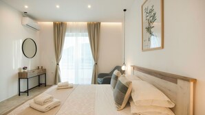 A modern hotel room with a bed, bedside table, and a large window with curtains. - Kathys Apartment 1 in Archaggelos (Archangelos)