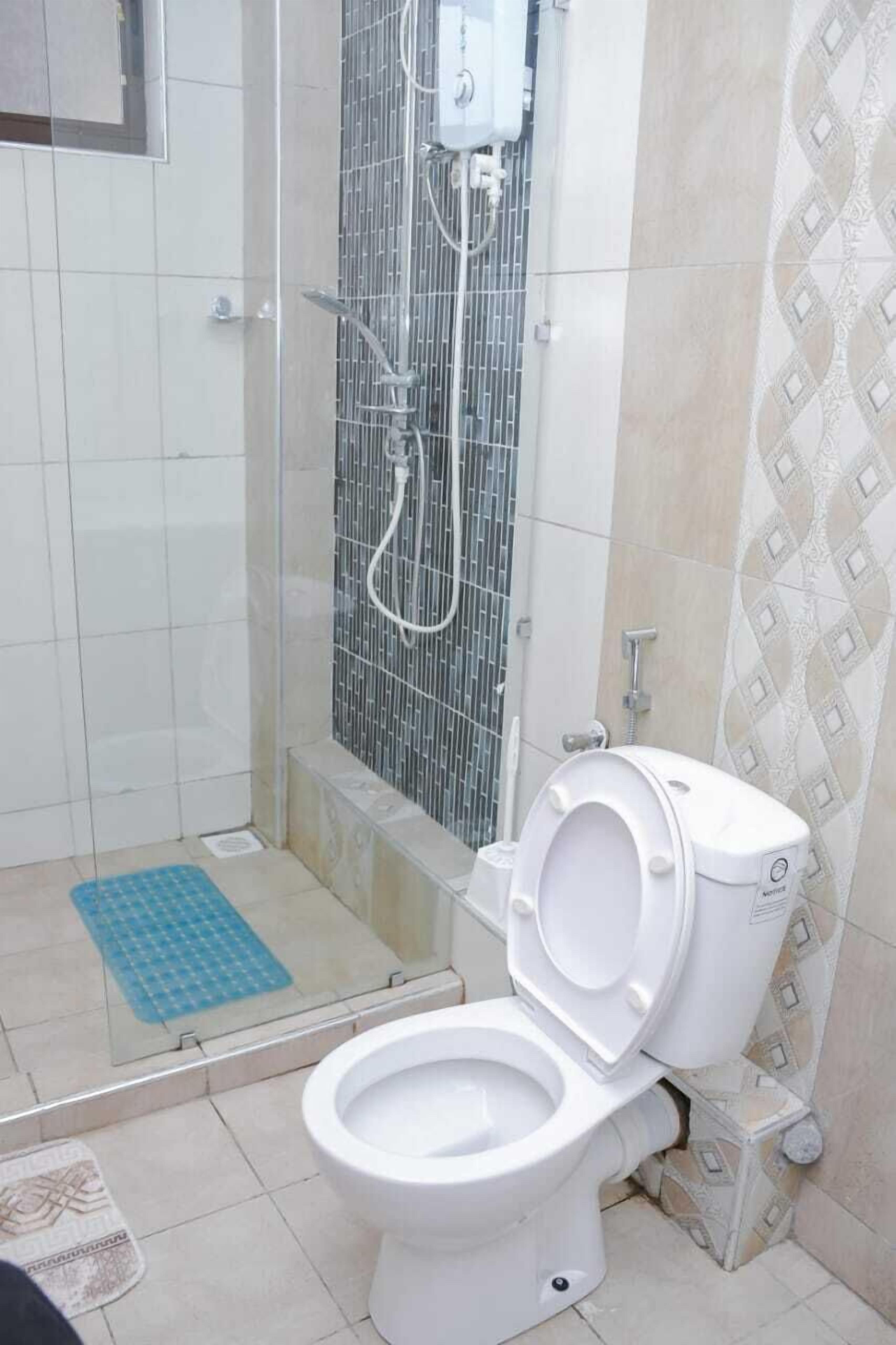 A bathroom with a shower enclosure, a toilet, and a bidet.