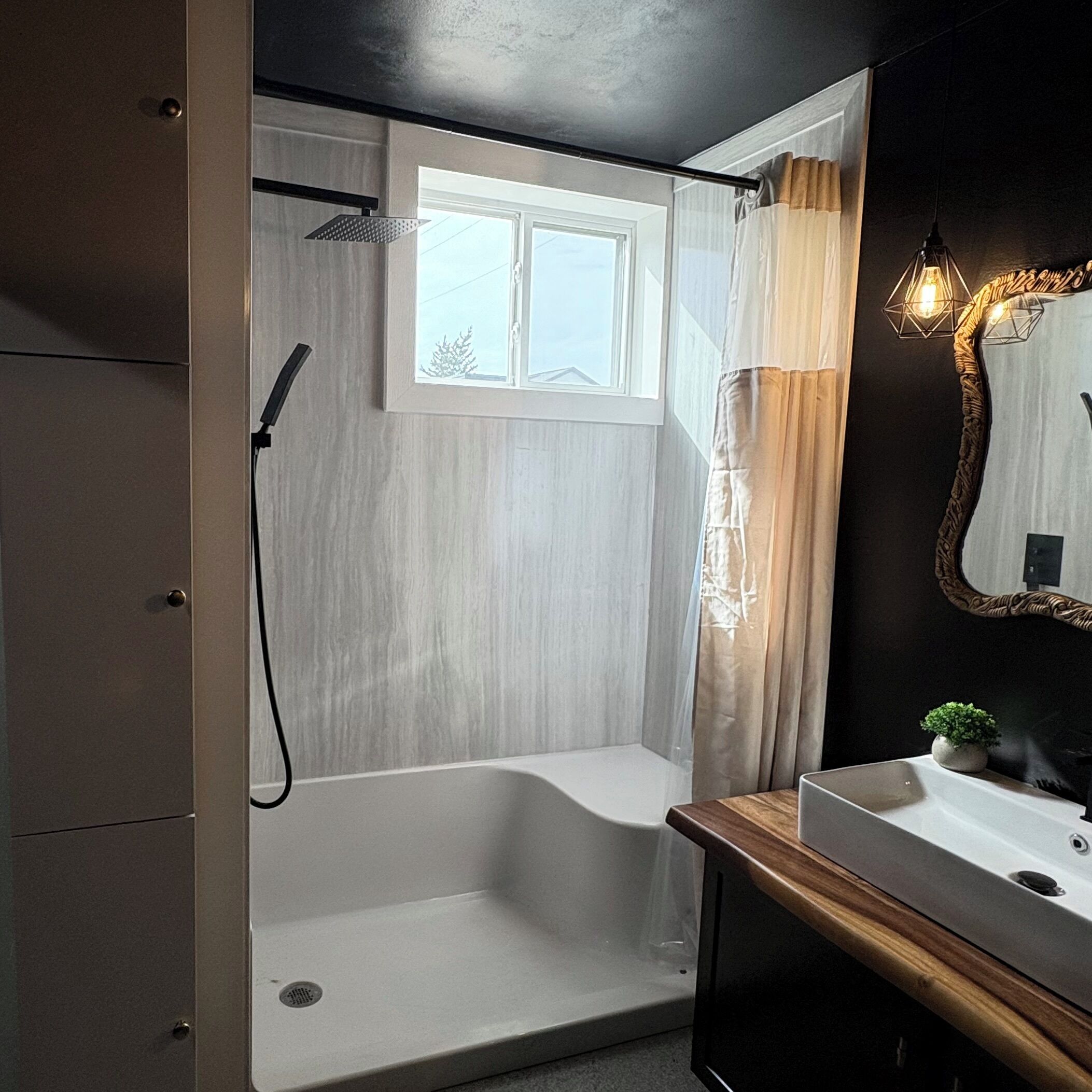 Une salle de bain moderne avec une douche à l’italienne, une fenêtre, un lavabo et un miroir.